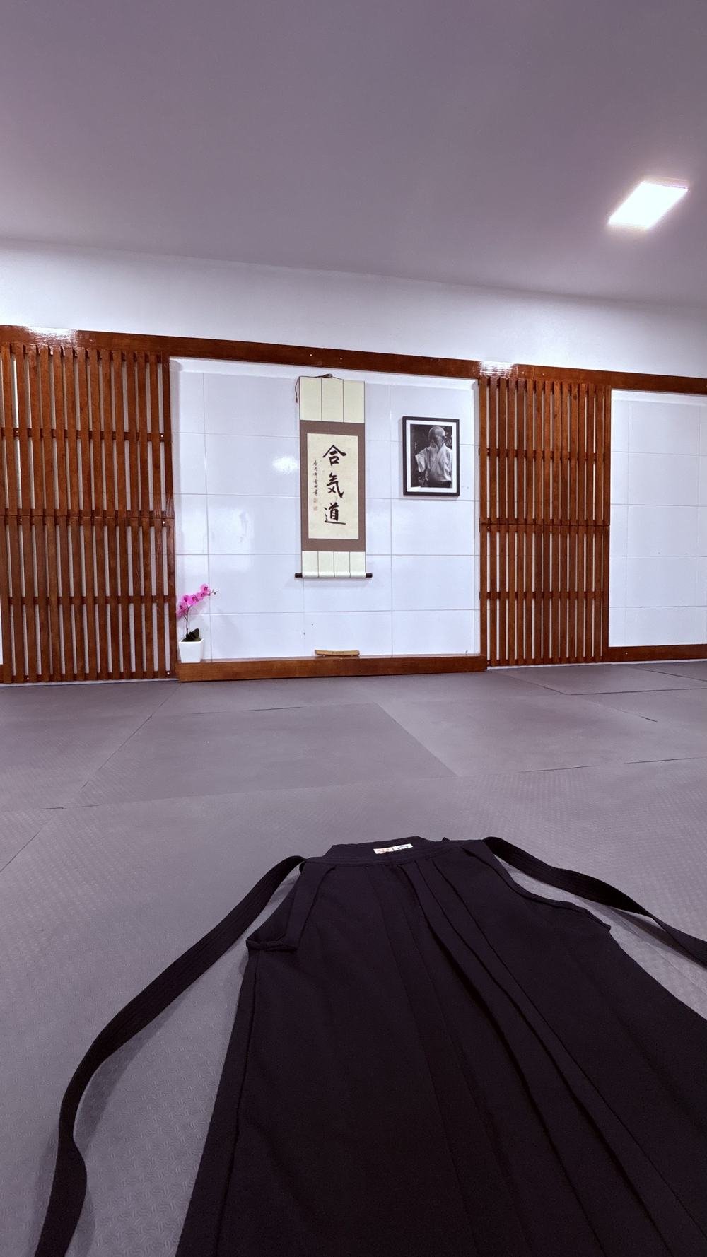 Hakama dobrado sobre o tatame, diante do kamiza do dojo