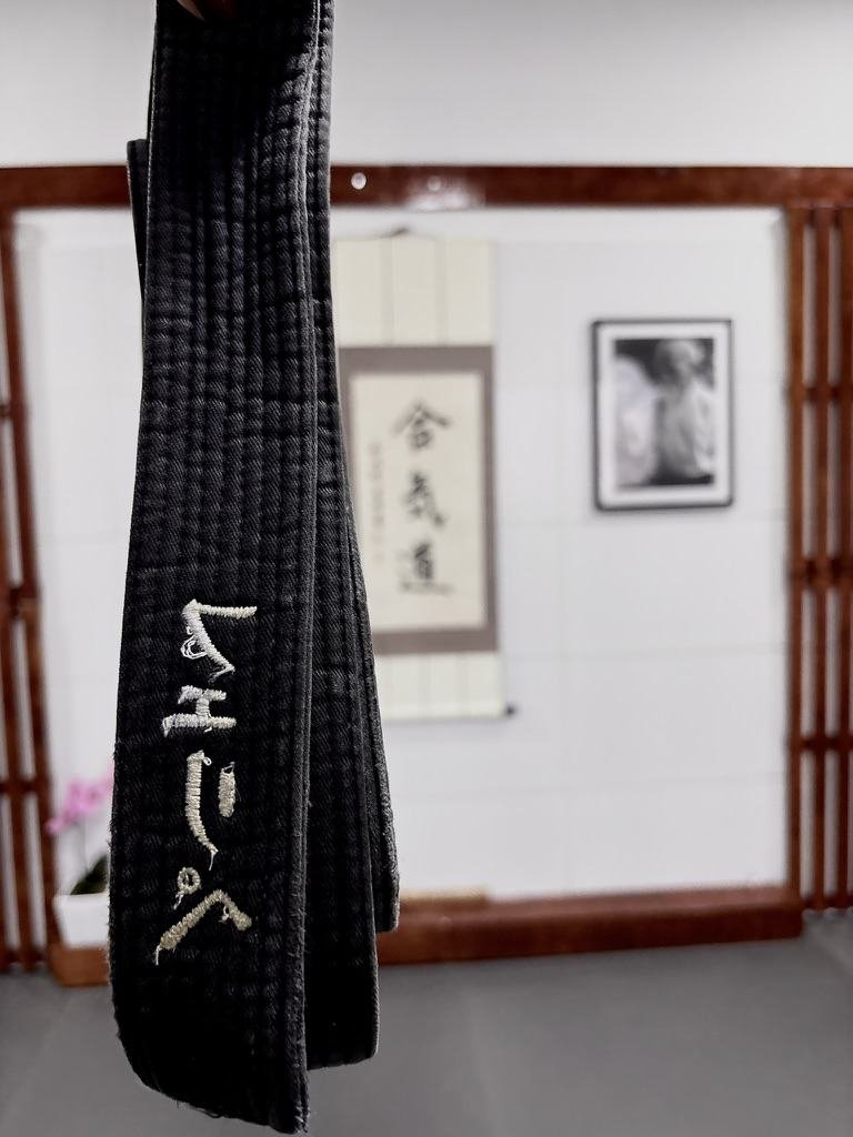 Detalhe da faixa (obi) bordada com o nome do dojo em japonês