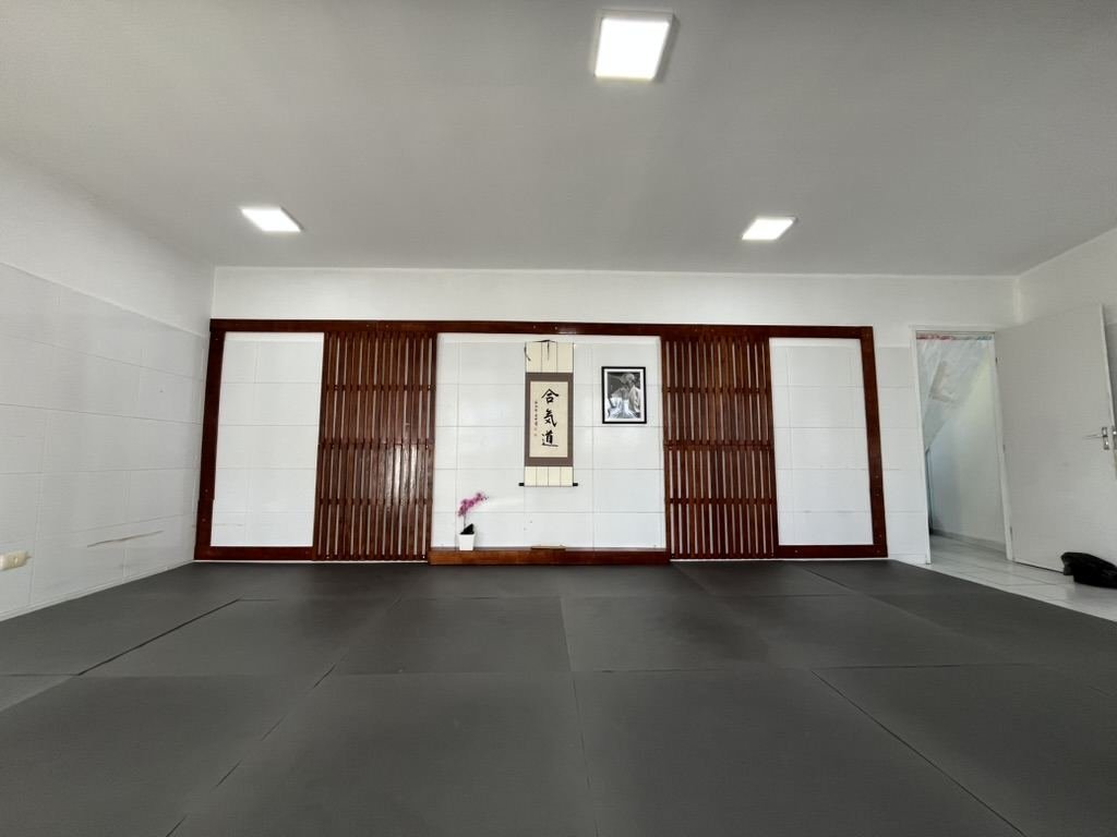 Tatame do Mokusai Dojo, com o kamiza (altar) ao fundo exibindo a caligrafia Aikido